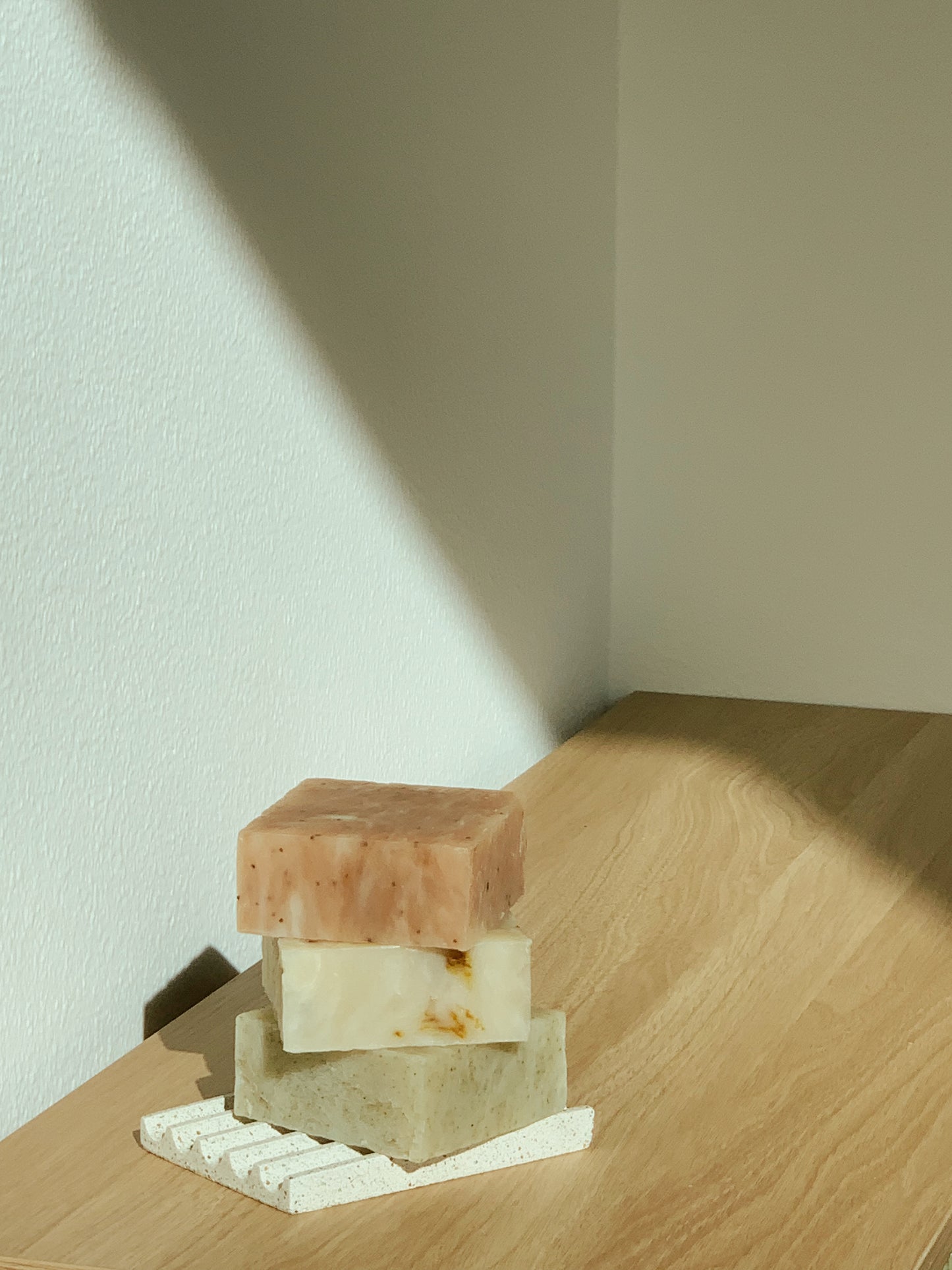 Stack of bar soaps on a soap dish, front view