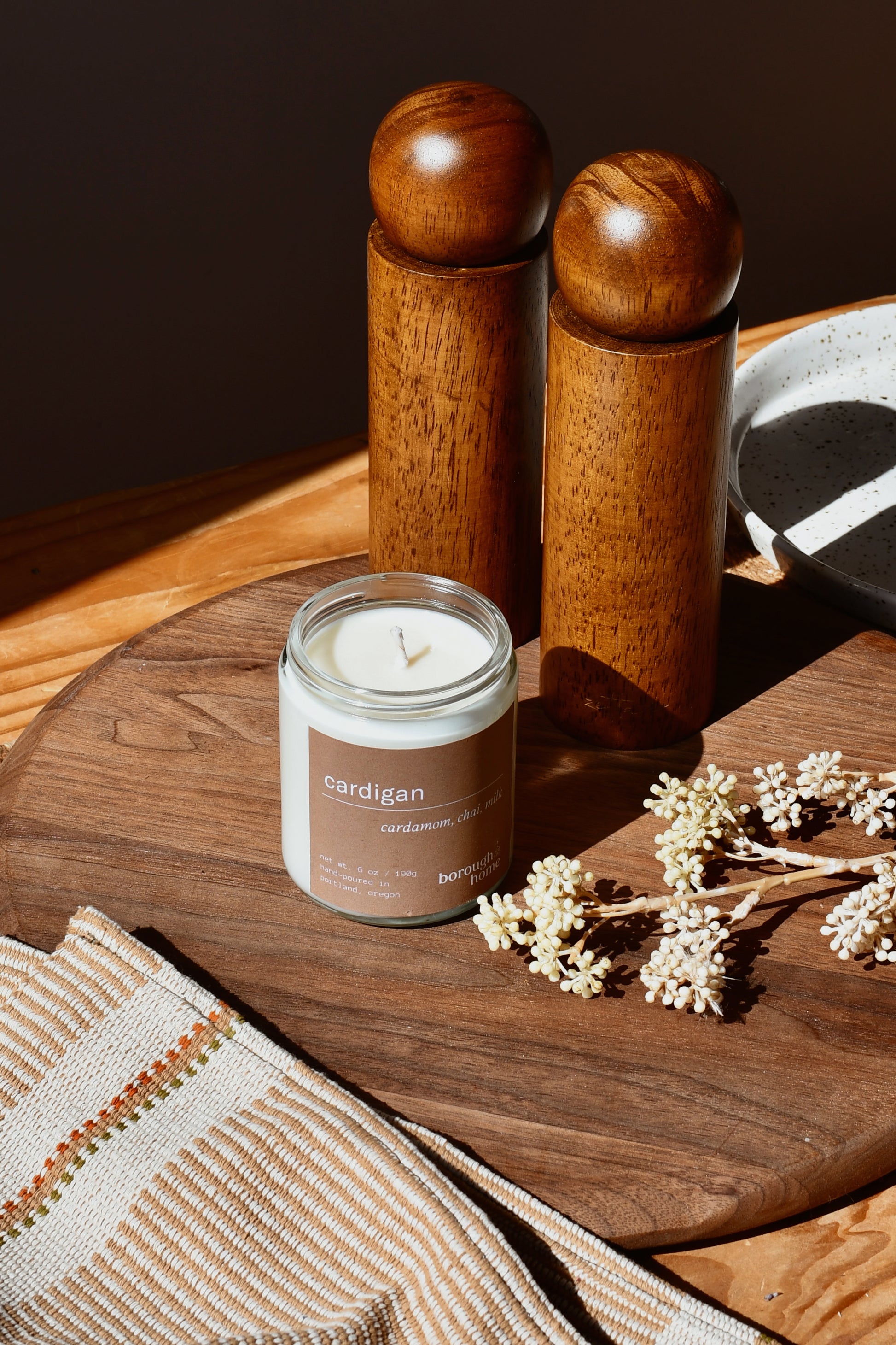 Cardigan candle on a wooden board, top down view.