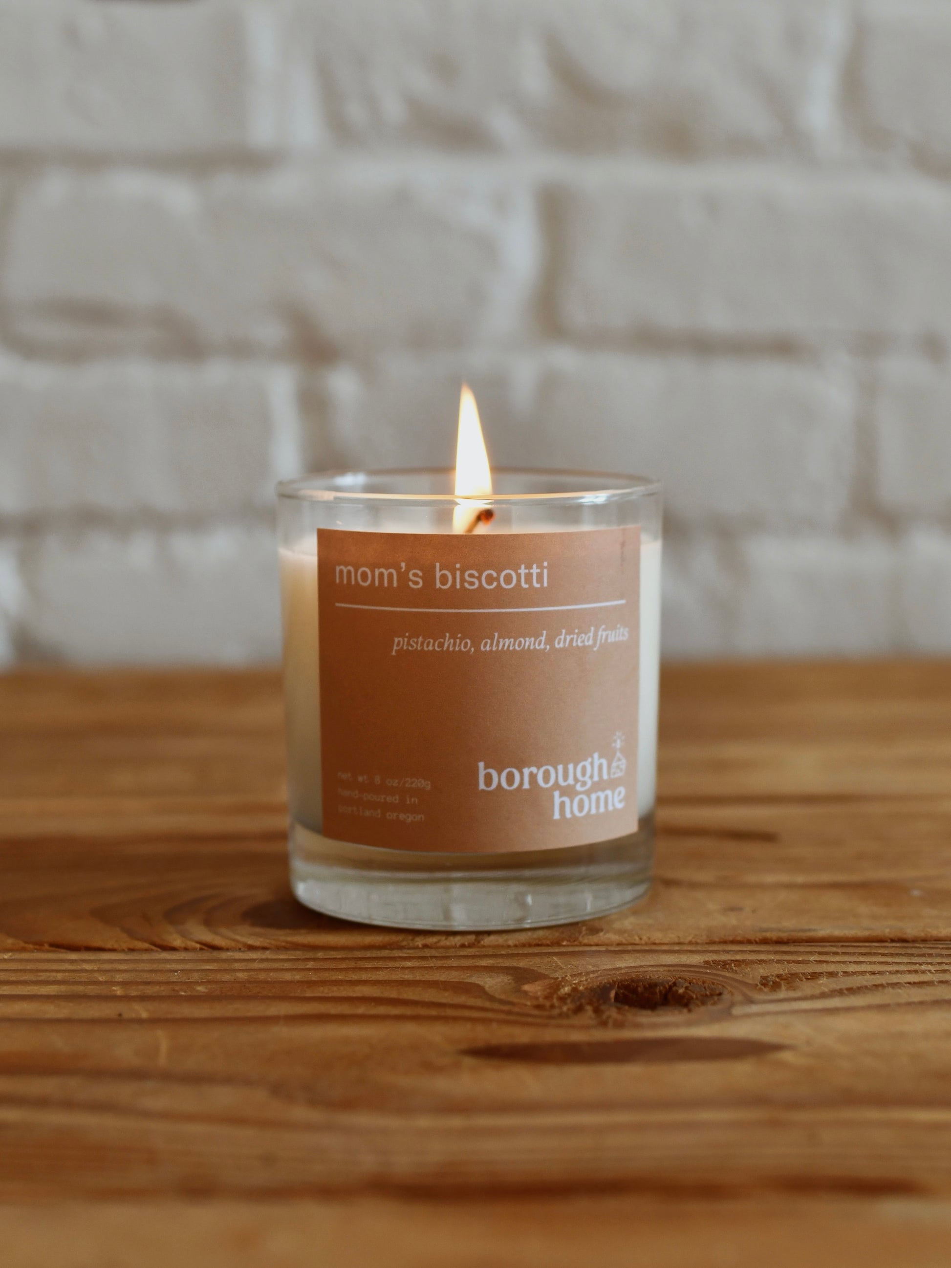 Mom's Biscotti candle against plain background, front view.