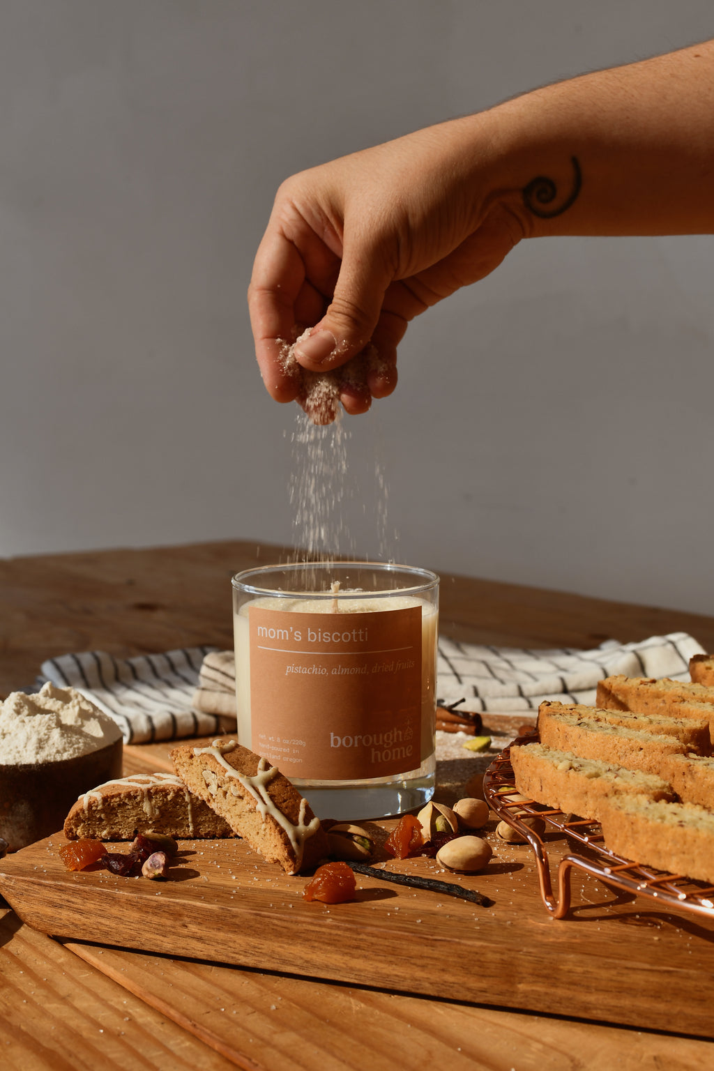 Mom's Biscotti candle with hand sprinkling sugar and cookies, front view.