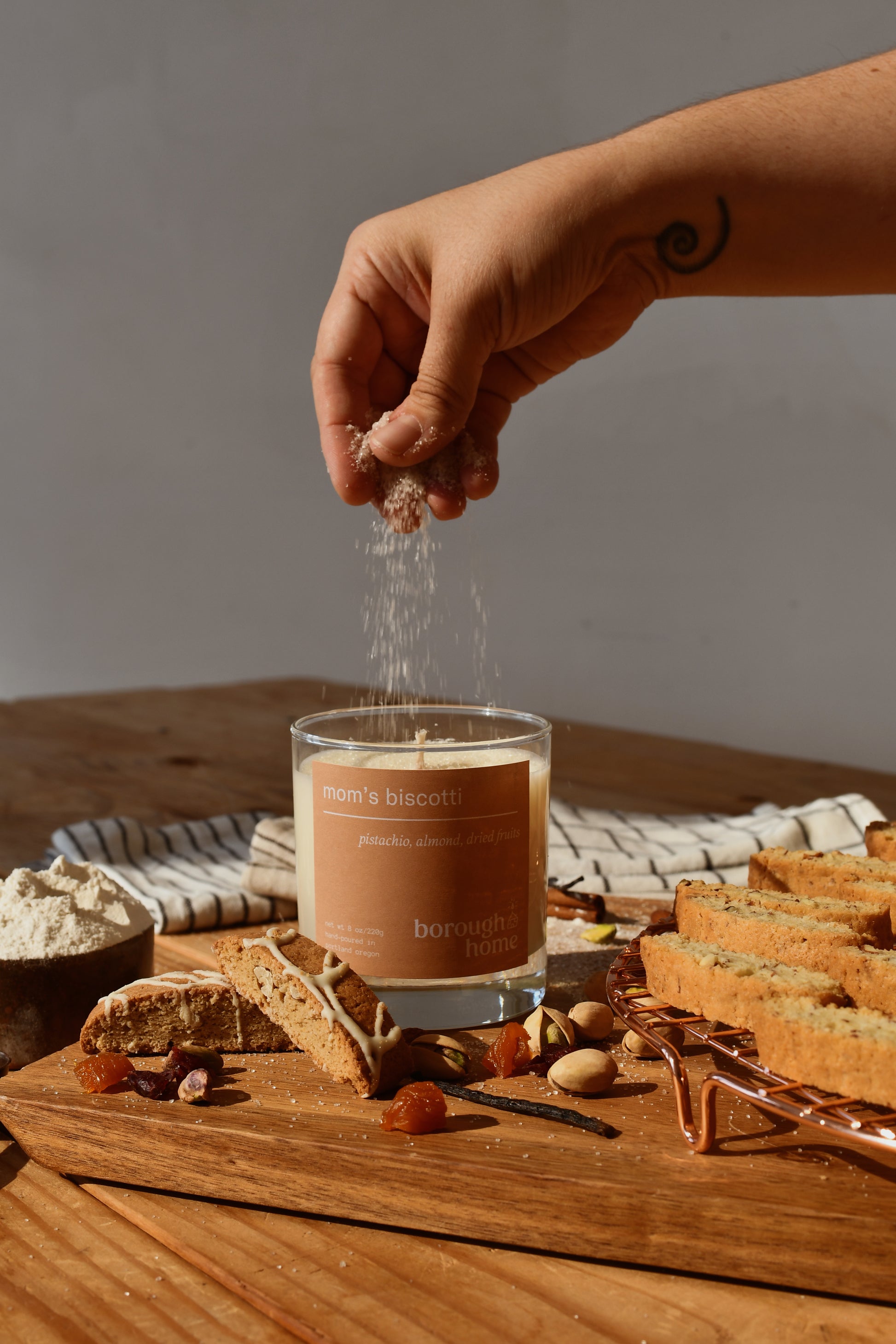 Mom's Biscotti candle with hand sprinkling sugar and cookies, front view.