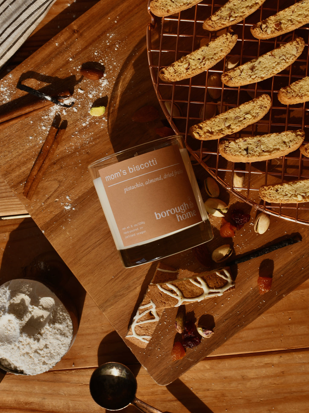 Mom's Biscotti candle, top-down view next to various baking ingredients and cookies.