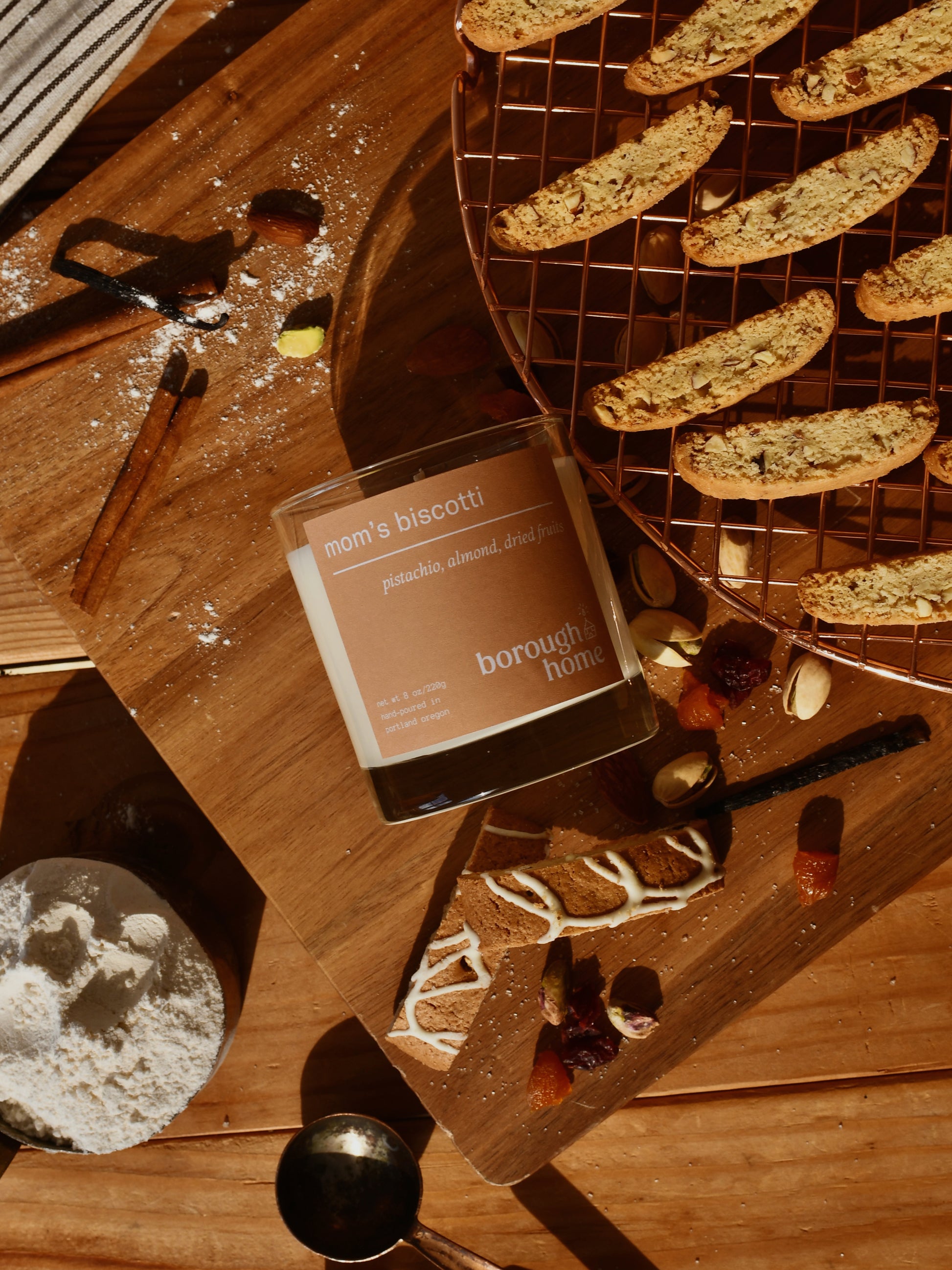 Mom's Biscotti candle, top-down view next to various baking ingredients and cookies.
