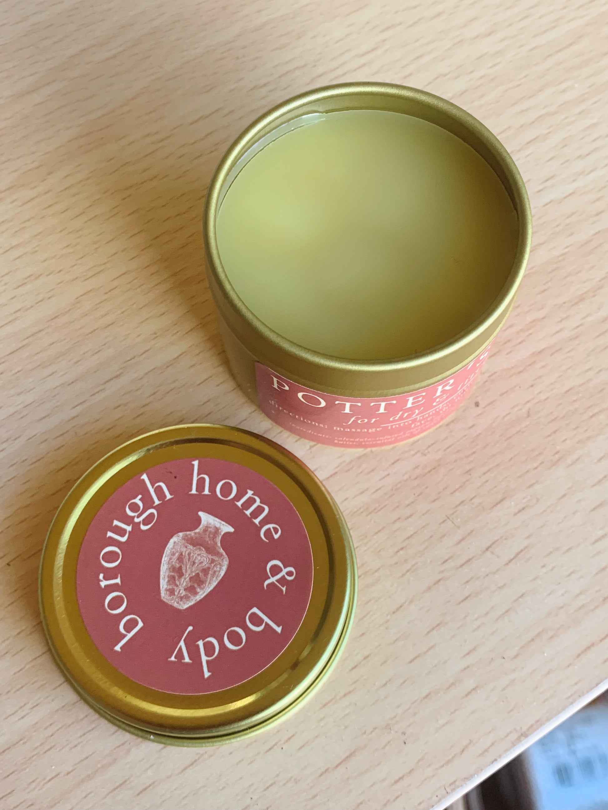Two tins of Borough Home & Body hand salve on a wooden surface